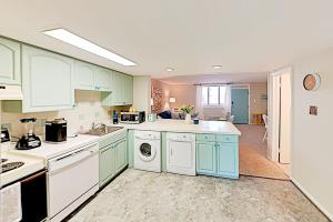 a kitchen with blue cabinets and a washer and dryer at Colonial Unit 202 in Ocean City +15 photos