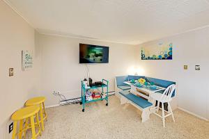 a living room with a table and chairs and a tv at Colonial Unit 202 in Ocean City