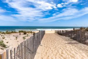 a fence on the beach with the ocean in the background at Sunny Day in Ocean City