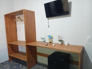 a desk in a room with a tv on a wall at Casa de Família Coração Amazônico in Alter do Chao