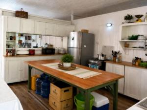 a kitchen with a wooden table and a refrigerator at SMITH'S BNB ROOMS in Georgetown