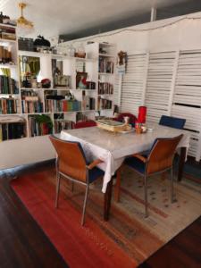 a dining room table with two chairs and a book shelf at SMITH'S BNB ROOMS in Georgetown