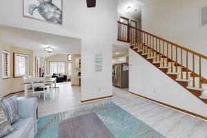 a living room with a staircase and a dining room at Trinity Place Treasure in Ocean Pines