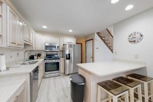 a kitchen with white cabinets and stainless steel appliances at Trinity Place Treasure in Ocean Pines
