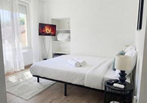 a white bedroom with a bed with towels on it at L'Opale in Roanne