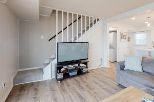 a living room with a television and a staircase at 14 Clipper on the Bay in Ocean Pines