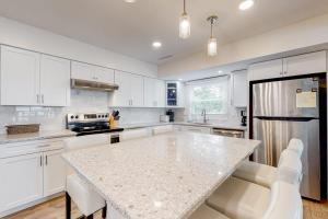 a kitchen with white cabinets and a marble counter top at 14 Clipper on the Bay in Ocean Pines +41 photos