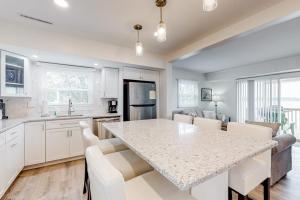 a kitchen with a large marble table and white cabinets at 14 Clipper on the Bay in Ocean Pines