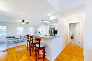 a kitchen and living room with a counter and stools at 5 Whitecap in Ocean Pines