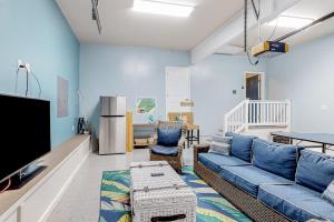 a living room with a blue couch and a tv at Turtle Shores in Ocean Pines