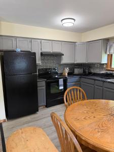 a kitchen with a black refrigerator and a table at Maple Ridge Trail Side Cabin in Crandon +17 photos