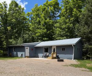 a gray barn with a white garage at Maple Ridge Trail Side Cabin in Crandon