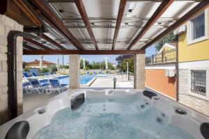 a jacuzzi tub with a view of a pool at Villa Suzanne in Banjole +54 photos