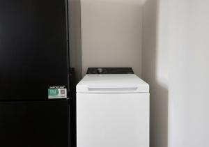 a white refrigerator and a black refrigerator freezer at L'Opale in Roanne