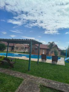 a picnic table and two benches next to a pool at Cabaña 6D in Concordia