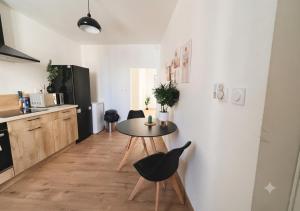 a kitchen with a table and chairs in a room at L'Opale in Roanne
