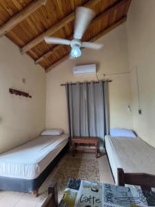 two beds in a room with a ceiling fan at Cabaña 6D in Concordia