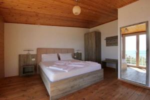 a bedroom with a bed and a large window at Shengjin villa in Shëngjin