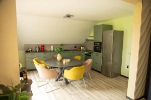 a kitchen with a table and yellow chairs in a room at Narnia in Heede