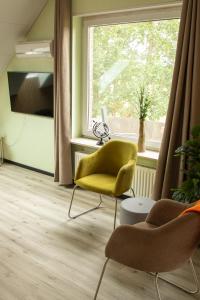 a living room with a yellow chair and a window at Narnia in Heede