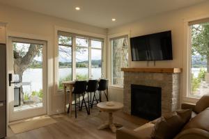 a living room with a fireplace and a tv at The Point on Wood Lake in Lake Country