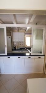 a kitchen with white cabinets and a counter top at Donna Rosa - Main Avenue in Taormina