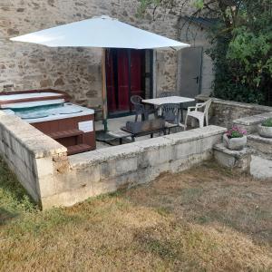 a patio with a table and an umbrella at Badger Cottage in Salagnac
