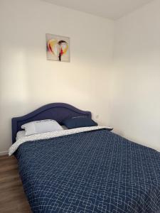 a bedroom with a blue bed with a picture on the wall at Vikendica Fenix in Banja Luka +13 photos