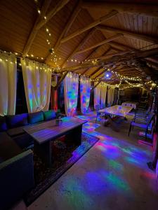 a room with a table and a couch and lights at Casa Fericirii in Cârțișoara