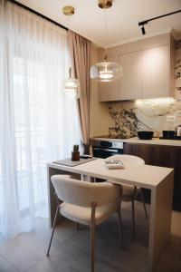a kitchen with a white table and a white chair at Villa Harmonia in Glavati