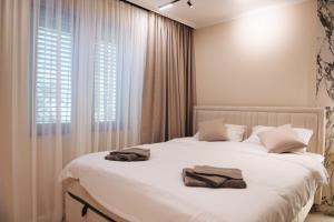 a bedroom with a white bed with two towels on it at Villa Harmonia in Glavati +44 photos