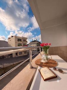 a table with a book and a vase of flowers on a balcony at Golden Homes in Bostancı
