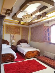 a bedroom with two beds and a chandelier at Nagar Villa Apartments in Luxor +176 photos