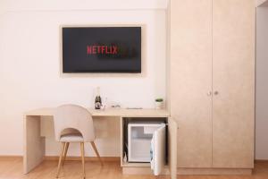 a desk with a chair and a tv on a wall at Pensiunea Cavaler in Baile Felix