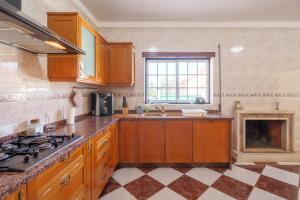 a kitchen with wooden cabinets and a fireplace at Família de Arega in Arega