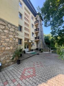a building with a stone walkway in front of it at Casa Bocan in Geoagiu Băi