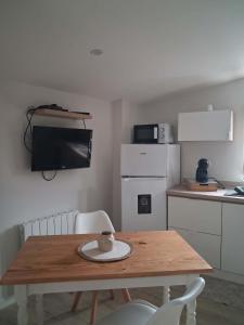 a kitchen with a wooden table and a kitchen with a counter at studio in Saint-Georges-de-Luzençon +6 photos