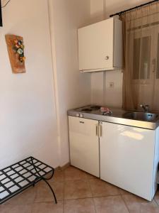 a small kitchen with a sink and a white refrigerator at Sunset elafonisos in Elafonisos