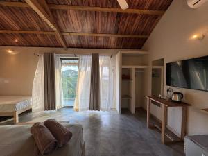 a bedroom with a bed and a tv and a window at La Cabane D Eté in Port Mathurin