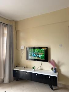 a living room with a tv on the wall at Luxe homes kenol in Kabuku