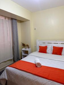 a bedroom with a large bed with red pillows at Luxe homes kenol in Kabuku