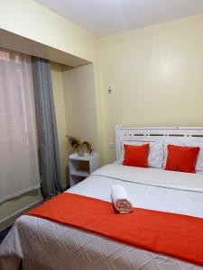 a bedroom with a large bed with red pillows at Luxe homes kenol in Kabuku +5 photos