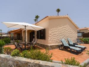 a patio with a table and chairs and an umbrella at Sunny Haven I in Maspalomas