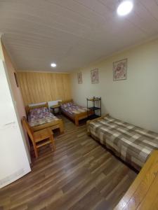 a room with two beds and a table and chairs at Pod lasem domek letniskowy in Susiec