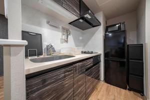 a kitchen with a sink and a refrigerator at Lotus south in Sapporo