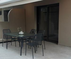 a black table and chairs in a room with a glass door at Aelith Rooms in Platamonas +43 photos