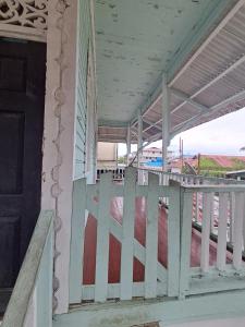 a porch of a house with a white railing at Hostal South beach in Carenero