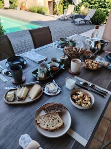 a table with plates of food on top of it at Maison d'hôtes Beauregard in Donneville