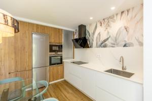 a kitchen with white counters and wooden cabinets at Prado Essence in Sanxenxo