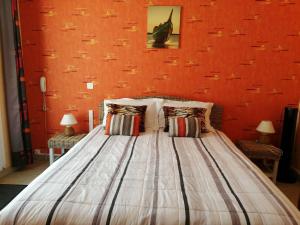a bedroom with a bed with an orange wall at La Sauldraie gîte in Salbris